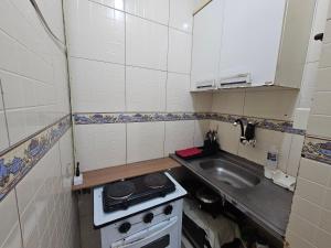 a small kitchen with a stove and a sink at A uma quadra da praia de Copacabana in Rio de Janeiro