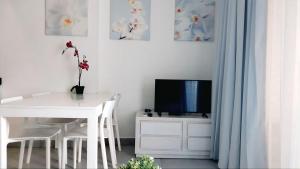 ein weißes Esszimmer mit einem weißen Tisch und einem TV in der Unterkunft Punta Cana Beach & Garden B&B 1 in Punta Cana + 25 Fotos