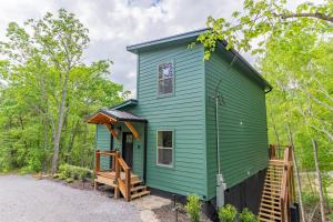 a green tiny house in the woods at Green & Black Bear Cabins By Beyond Expectations in Sevierville