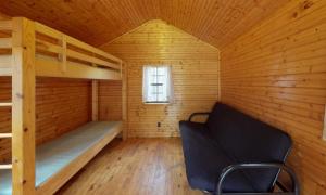 een kamer met 2 stapelbedden en een stoel bij Jellystone Park PA Wilds in Mansfield