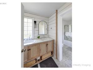 un bagno con lavandino e specchio di Lake House - Pacific City a Tierra Del Mar Altre 28 foto