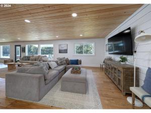 un soggiorno con divano e TV a schermo piatto di Lake House - Pacific City a Tierra Del Mar