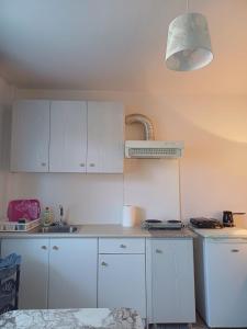 a kitchen with white cabinets and a white counter top at Marys Home Eretria in Malakóndas