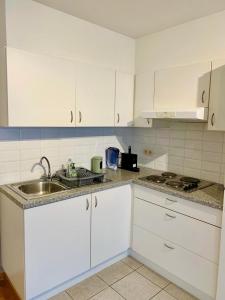 奥斯坦德Relaxed coastal stay - steps from beach & center的带白色橱柜和水槽的厨房