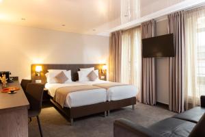 Postel nebo postele na pokoji v ubytování Hotel Choiseul Opera