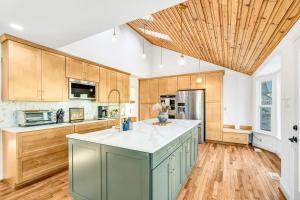 a large kitchen with wooden cabinets and a wooden ceiling at Woodhaven Reserve by STREAM in Purcellville