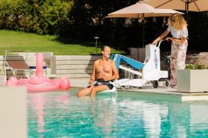 um homem sentado na água numa piscina em Bed & Breakfast L'Albero Maestro em Borgofranco dʼIvrea