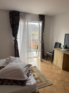 a bedroom with a bed and a view of a balcony at Elitegasthaus Moieciu A in Moieciu de Jos