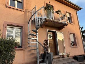 a house with a spiral staircase next to a door at Gîte le Nid in Uffholtz