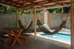 a patio with two hammocks and a pool at Pipa Moaina Hale in Pipa
