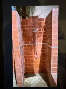 a red brick shower in a brick wall at Suite privée-chambre, salon et cuisine complete in Mbour