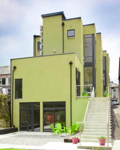 a green building with stairs and green chairs at Clody Lodge in Bunclody