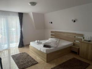 a bedroom with a bed and a large window at Elitegasthaus Moieciu A in Moieciu de Jos