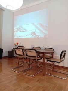 una mesa y sillas en una habitación con una pintura en Prestige Apartment Leone, en Roma