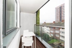 a balcony with a white table and chairs and a window at Central Modern 2BR Flat with Parking & Balcony in Liverpool