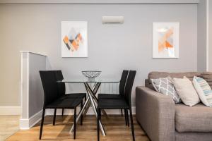 a dining room with a table and a couch at Central Modern 2BR Flat with Parking & Balcony in Liverpool