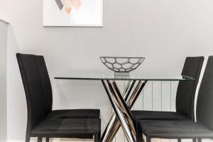 a glass table with two chairs and a bowl on top at Central Modern 2BR Flat with Parking & Balcony in Liverpool +16 photos