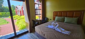 ein Schlafzimmer mit einem Bett mit einem weißen Band darauf in der Unterkunft Khumkatang Resort & Restaurant in Ban Bang Rong