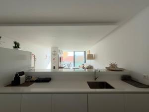 a kitchen counter with a sink and a window at Horizonte do Mar in Apúlia +13 photos