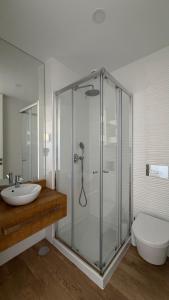 ein Badezimmer mit Dusche, Waschbecken und Toilette in der Unterkunft Horizonte do Mar in Apúlia