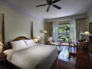 a bedroom with a large bed and a living room at Sofitel Angkor Phokeethra Golf & Spa Resort in Siem Reap
