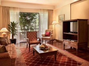 a living room with a television and a couch and chairs at Sofitel Angkor Phokeethra Golf & Spa Resort in Siem Reap +144 photos