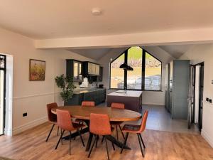 a kitchen and dining room with a wooden table and chairs at An Chill Bheag At the Blessington Lakes in Blessington