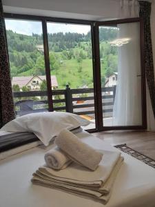 a bed with towels on it with a large window at Casa Maria Moieciu C in Moieciu de Sus +29 photos