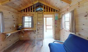 een hut met houten wanden, houten vloeren en ramen bij Jellystone Park PA Wilds in Mansfield