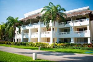 a large white building with palm trees and a sidewalk at Grand Riviera Princess - All Inclusive in Playa del Carmen
