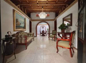 a living room with a couch and chairs and a table at Casa Amaru Rooms in Guarne