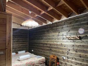 a room with a wooden wall with a bed at Ohel in Mullini i Danit