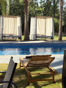 twee stoelen en een tafel naast een zwembad bij Villa Sofia And Spa in Marrakesh