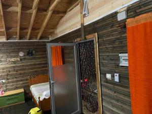 a metal refrigerator in a room with wooden walls at Ohel in Mullini i Danit