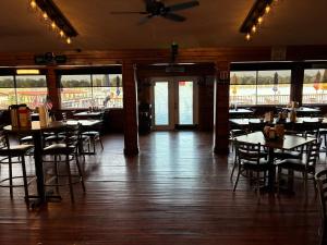 ein Esszimmer mit Tischen, Stühlen und Fenstern in der Unterkunft Porky's Lodge, Bar & Grill in Georgetown