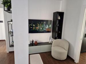 una sala de estar con una silla y una foto en la pared en Beki's apartment, en Alba