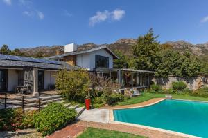 a house with a swimming pool in the yard at Watermill Ocean View Luxury Family Retreat in Gordonʼs Bay