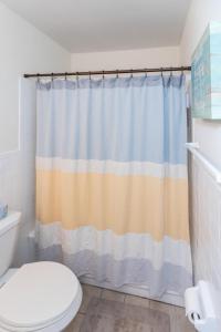 a bathroom with a shower curtain and a toilet at Latitude Adjustment in Virginia Beach +39 photos