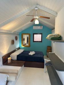 ein Schlafzimmer mit einem Bett und einem Deckenventilator in der Unterkunft Vila dos Tangarás, Casa 1 Praia, a 30m do mar in Toque Toque Grande
