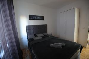 a bedroom with a large bed with two towels on it at Stan na dan Luna in Smederevska Palanka