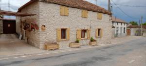 a stone building with yellow shuttered windows on a street at Casilla Fuentes in Fuentes de Cuéllar