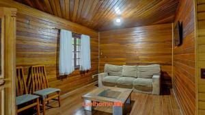 a living room with a couch in a wooden room at Casa em Mangaratiba com 3 suites e Vista Mar in Mangaratiba