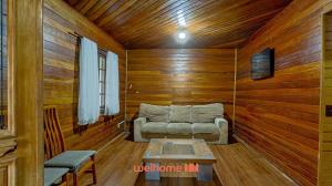 a living room with a couch in a room with wooden walls at Casa em Mangaratiba com 3 suites e Vista Mar in Mangaratiba
