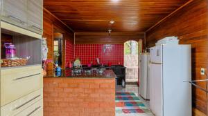 a kitchen with a white refrigerator and red tiles at Casa em Mangaratiba com 3 suites e Vista Mar in Mangaratiba +31 photos