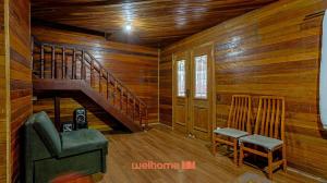 a room with wooden walls and a staircase and two chairs at Casa em Mangaratiba com 3 suites e Vista Mar in Mangaratiba