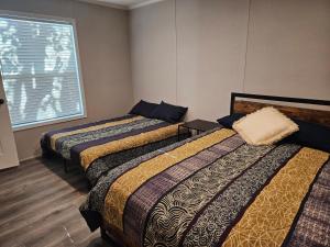 two beds in a room with a window at West Battle Lake w Lake Views in Battle Lake