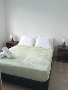 a bedroom with a large bed with white sheets and pillows at Encantador refugio enclavado en las montañas in Guadual +12 photos