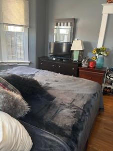 a bedroom with a bed and a dresser with a television at Woodbridge Heritage Home in Vaughan