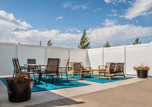 a patio with a table and chairs and a fence at Canalta Oyen in Oyen