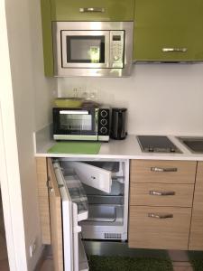 a kitchen with a microwave and a stove at Escapade Au Soleil in Gréasque